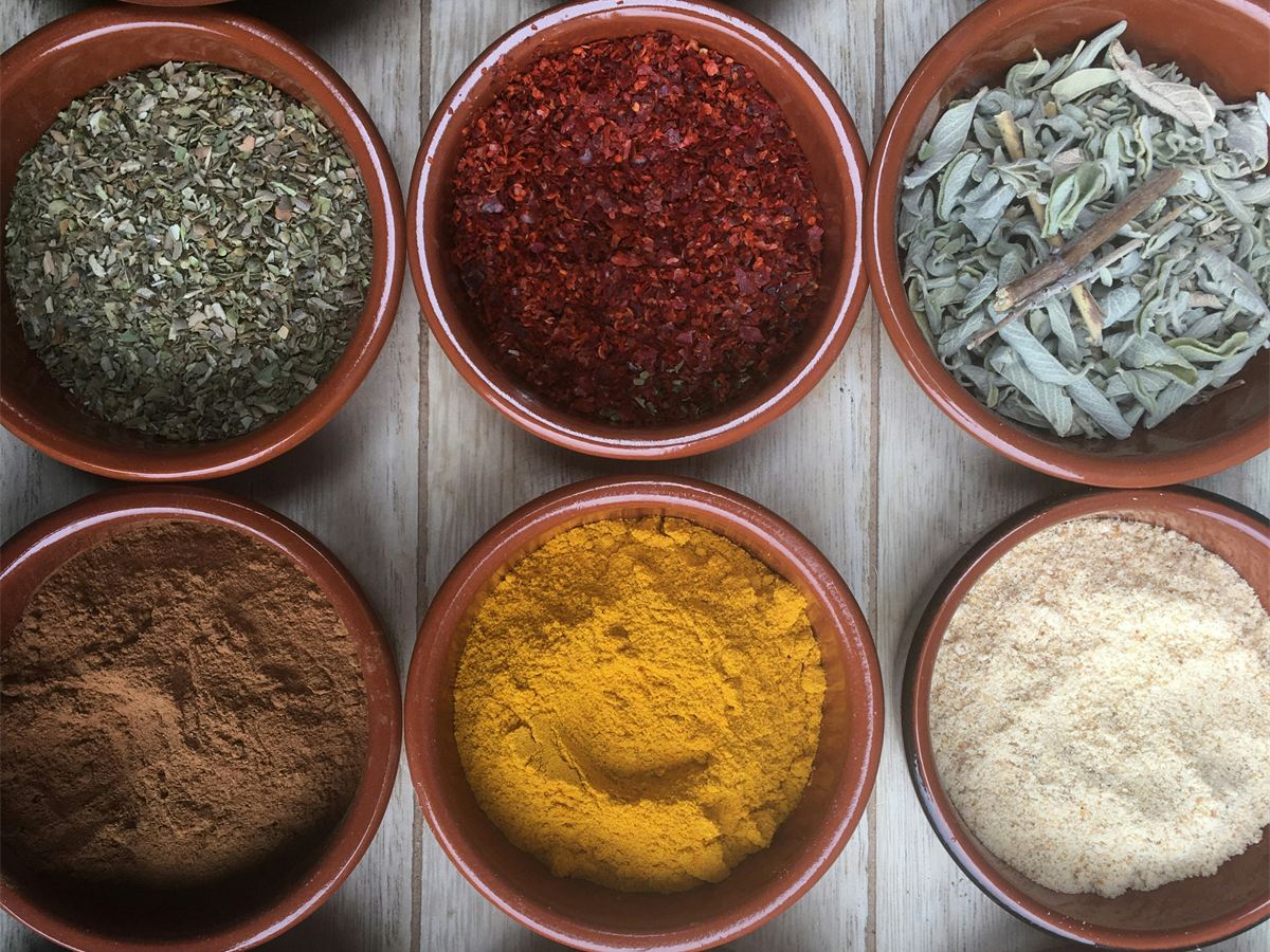 Bowls of ground spices, herbs and cloves